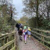 Continue straight ahead on the main path which has a hard surface with some loose rocks. Pass the reeds and bear left onto a wooden walkway.