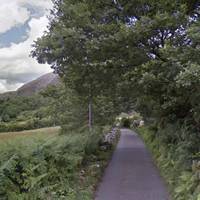 Soon the path emerges onto a lane beside a road bridge.  Continue walking along this quiet lane, separated from the river now by a field