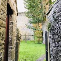 Find a narrow passageway between two shops, leading into the churchyard.