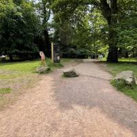 When you reach the small accessible car park, turn right on the path pass a few large boulders which span the path.