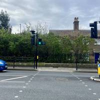 Cross over at the pedestrian crossing and turn left on the other side of the road.