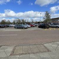 Turn right at the tactile pavement and cross the car park access lane when safe to do so.