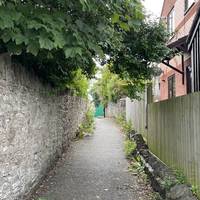 Follow the tarmac path to the left of the houses.