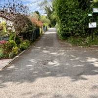 Follow the direction of the Loop sign up hill alongside the row of houses.