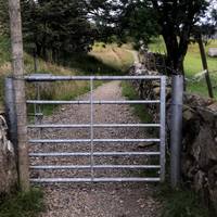 Walk up the road about 3/4 mile where there’s a junction of paths. Go through this small metal gate set back on the right. 