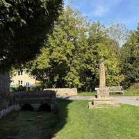 At the corner a bridge crosses the river, at the time it was very shallow. Take a left turn here down Church Walk.