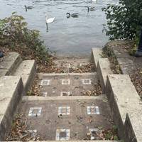 Walk away from the bridge & past these tiled stairs.  Head to the road to continue along the pavement momentarily.