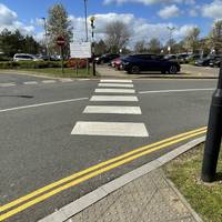 Head over the zebra crossing by the tactile paving when safe to do so.