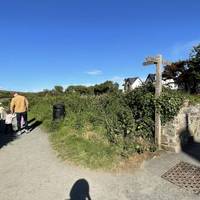 Shortly after the road bends right, turn left onto the tarmac path, part of the Pembrokeshire Coast Path 🐚