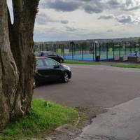 Enter the playground. Carefully cross the car park and turn left following the path in front of the fenced sports court.