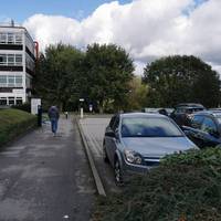 Turn right between a hedge and a car park.