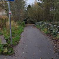 In about 100 m, go half right down a paved ramp sign posted for little lever and Bury.