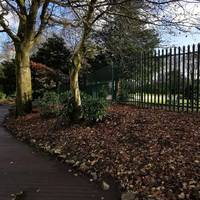 The smooth and level path veers right between lines of stones with views over the bowling green.