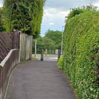 Head across the roundabout, then head onto the footpath between the house and the hedge out onto the next road.