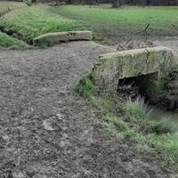 Aim at 10 o'clock from  bank and cross ditch at the  bridge.